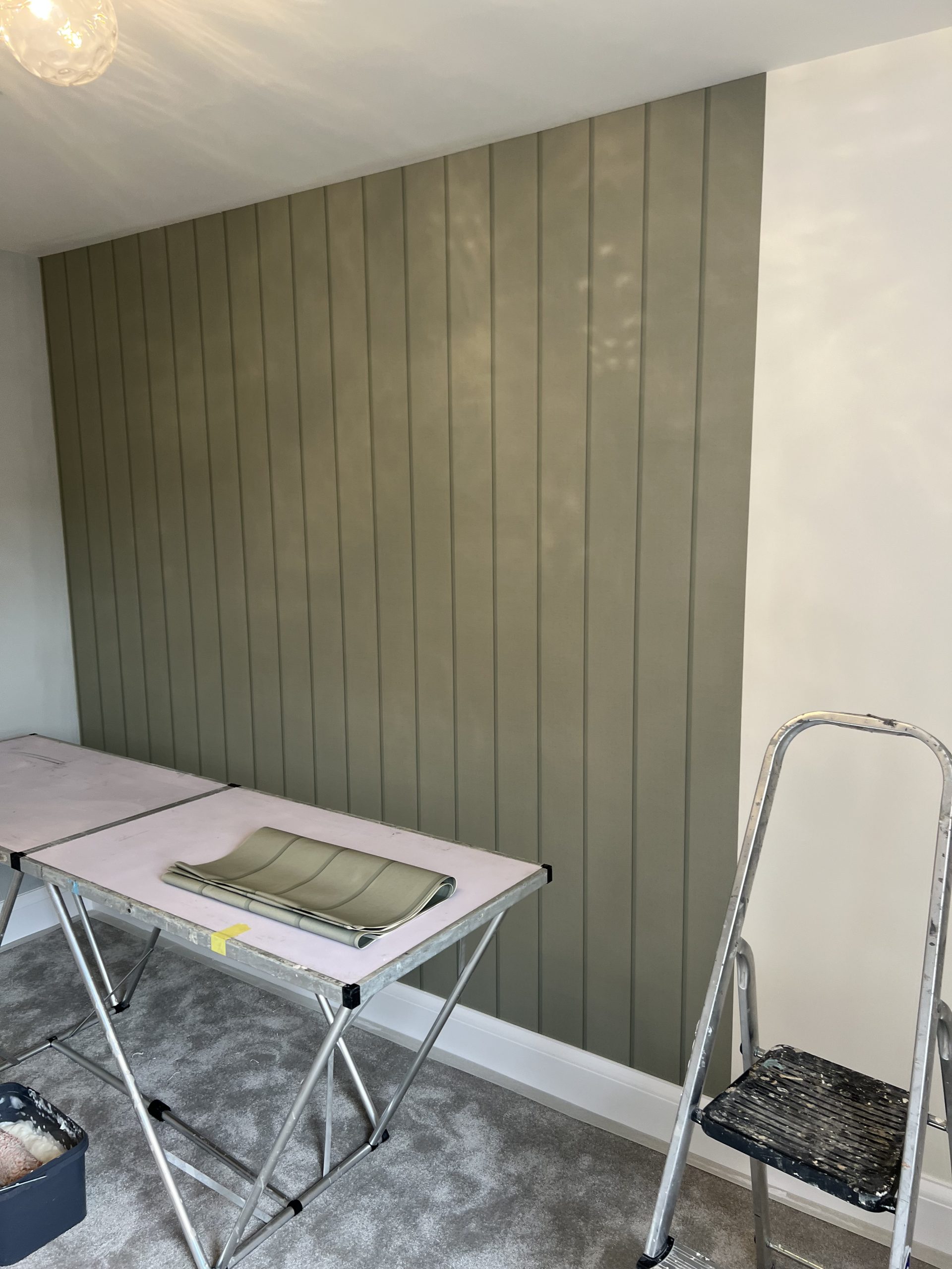 Sage green painted panelled feature wall in a finished interior